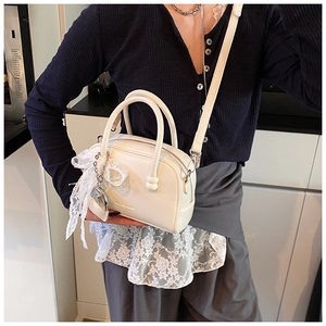 White bowling shoulder bag for women, stylish PU leather handbag with cute lace bow charm.