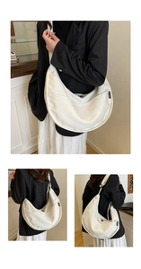 Detail view of white crescent canvas bag with adjustable strap and side woven label tag