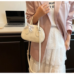 Detail of a beige PU leather handbag with a Just For You ribbon on the handle