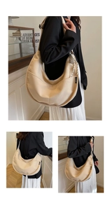 Detail of beige hobo canvas bag with woven brand tag and decorative zipper pull