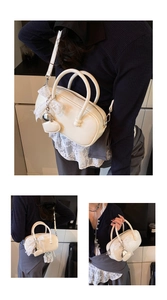 Détail du sac bowling vintage crème avec nœud en dentelle et breloque cœur sur mannequin