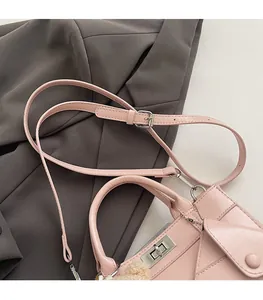 Détail du sac bandoulière rose avec fermoir en métal argenté et breloque peluche