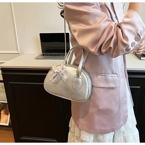 Detailed close-up of a silver bowling bag with lychee texture and a satin bow detail
