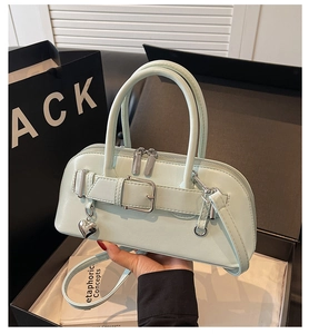 Détail du sac à main vert menthe avec pendentif cœur argenté et boucle métallique chic