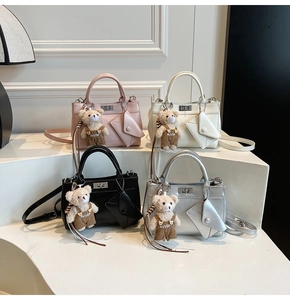 Vue détaillée des sacs à main en cuir mat avec fermoir rotatif et pendentif d'ours en peluche