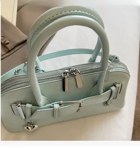 Détail des doubles fermetures éclair et du pendentif cœur sur le sac menthe