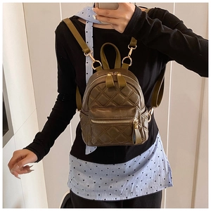 Nahaufnahme eines olivgrünen Mini-Rucksacks mit Rautensteppung und goldenen Details