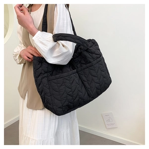 Close-up of black quilted tote bag featuring a V-shaped stitch pattern and fluffy texture