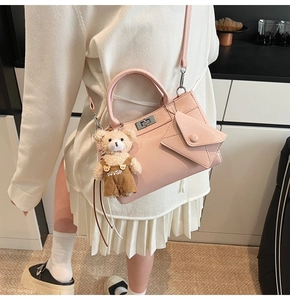 Détail du sac bandoulière rose en similicuir avec charm ours et pochette enveloppe assortie