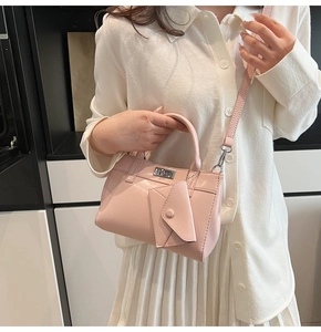Pale pink PU leather handbag detail with cylindrical handle and mini envelope charm pouch