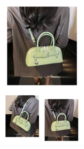 Détail du sac sous le bras vert menthe avec boucle décorative et pendentif cœur