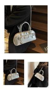 Détail du sac à main argenté avec boucle de ceinture et pendentif en forme de cœur