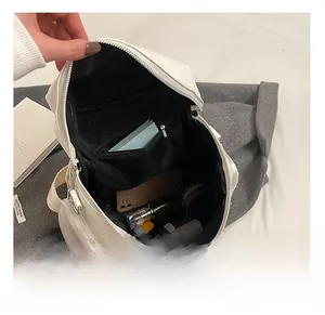 Internal view of the white leather backpack showing spacious storage and inner pocket