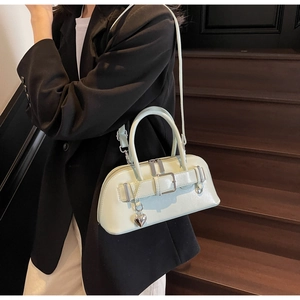 Détail d'un sac bowling vert menthe avec pendentif cœur et bandoulière réglable