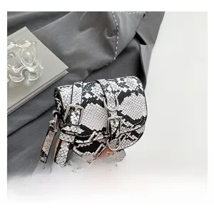 Close-up of black and white snakeskin print saddle bag with silver metal buckles
