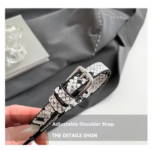 Close-up of adjustable snake-patterned faux leather shoulder strap with silver metal buckle
