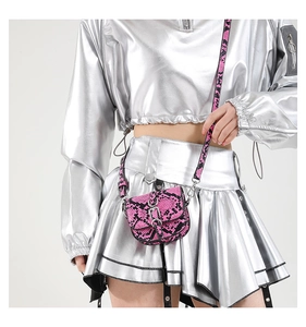 Detailed view of pink snake pattern mini saddle bag with silver metallic outfit