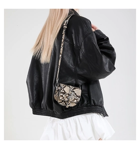 Detailed close-up of retro mini snakeskin saddle bag with adjustable strap and metal buckle