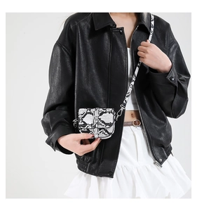 Close-up of mini saddle bag with snake skin pattern and silver metal buckle on model
