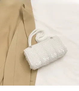 Close-up of pearl white beaded handbag with sequins and silver metal hardware details