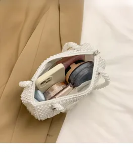Detailed internal view of pearl woven bag showing large capacity for phone and cosmetics