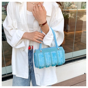 Outdoor shot of a light blue pearly sequin mini handbag with elegant silver hardware