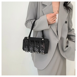 Detail view of black sequined pillow bag with woven pearl texture and chic top handle