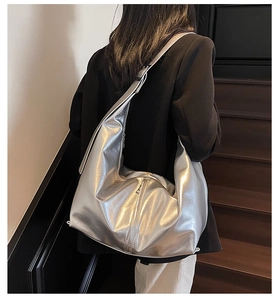 Détail du sac à bandoulière argenté métallisé montrant la surface texturée et plissée