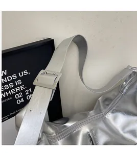 Détail du sac hobo argenté avec bandoulière réglable et boucle en métal poli brillant