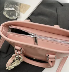 Détail du sac seau en cuir ciré rose avec fermeture éclair et ornement tressé
