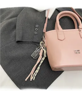Détail du sac seau en cuir rose avec breloque raquette de tennis et cordon tressé