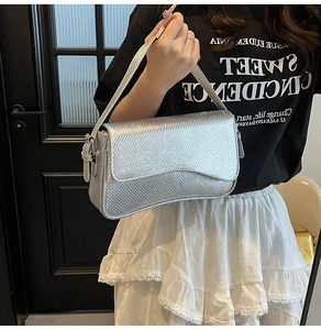 Detail of silver snake-pattern rectangular shoulder bag with metallic texture finish