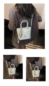 Détail du sac seau en cuir vert menthe clair avec pompon et accents de sangle tressée