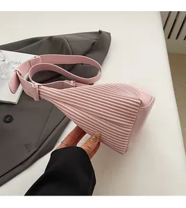Detail view of pink pleated handbag with soft texture and adjustable shoulder strap