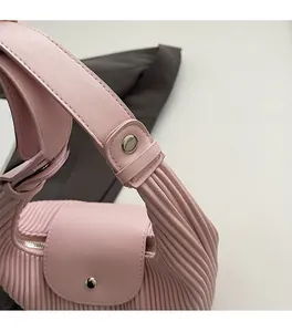 Macro detail of pink pleated handbag showing silver hardware and soft texture