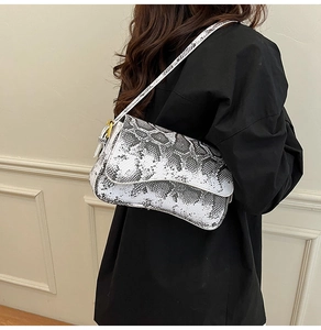 Close-up of black and white snake print pattern and gold hardware on the shoulder bag