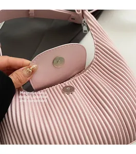 Detail of pink pleated leather bag showing functional metal magnetic closure design