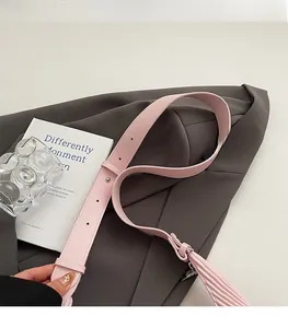 Detail of pink adjustable faux leather shoulder strap with silver metal buckle on blazer