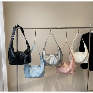 Cinq sacs Hobo style croissant en finition brillante accrochés au présentoir