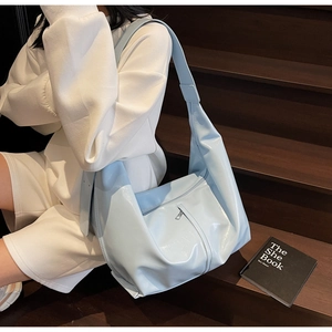 Détail du grand sac hobo bleu clair avec finition brillante et large bandoulière