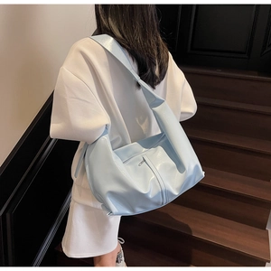Vue arrière du sac à bandoulière en cuir brillant bleu clair avec large bandoulière