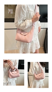 Detail of light pink pleated crescent bag showing the magnetic snap closure and texture
