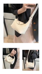 Detailed close-up of cream pleated shoulder bag showing fine leather texture and metal buckle