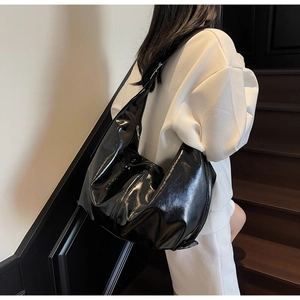 Détail du sac bandoulière en cuir verni noir brillant avec grand compartiment