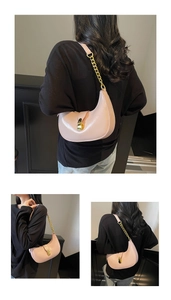 Detail of pink half-moon bag featuring a shiny finish and gold chunky chain strap