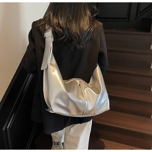 Détail du sac hobo argenté brillant avec large bandoulière et boucle métallique réglable