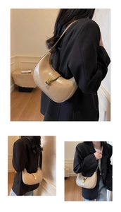 Detail of light khaki hobo bag with gold twist lock and leather chain strap
