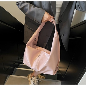 Détail du sac à bandoulière hobo rose en cuir verni brillant avec fermeture éclair en métal
