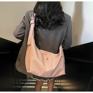 Pink crescent hobo bag shown from back with wide adjustable strap and zipper pocket