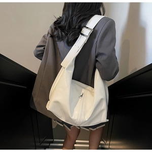 Détail du sac hobo en cuir PU blanc avec large bandoulière et boucle argentée sur mannequin